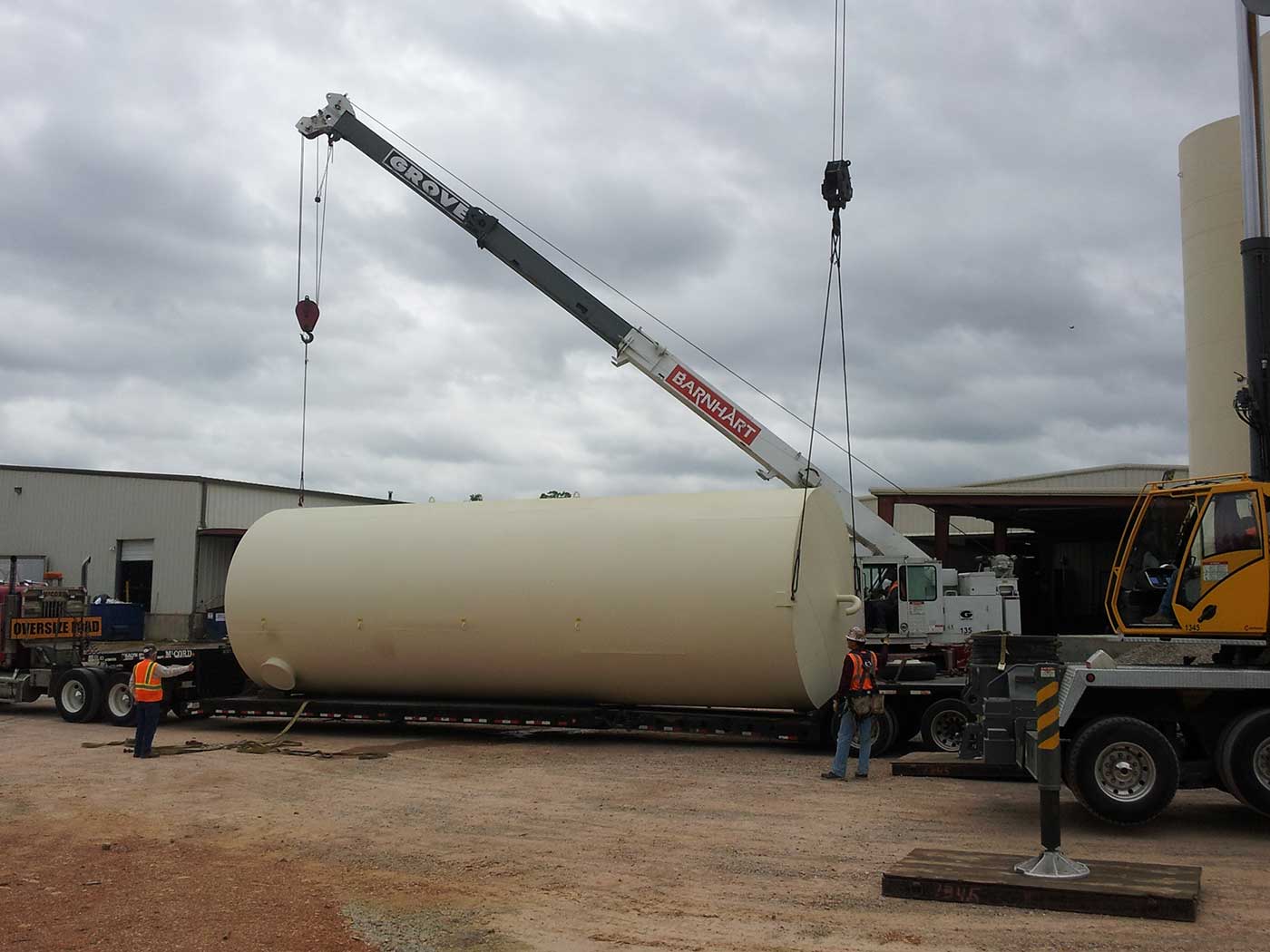 crane unloading large vertical tank